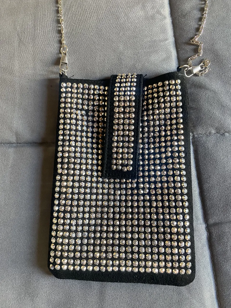 ¡Llevá tu celular con vos a todos lados con este súper práctico y canchero "phone crossbody"! Es negro, súper brilloso y está lleno de strass que le dan un toque glamoroso único. Ideal para salir de noche, ir a un evento o simplemente para darle un toque especial a tu look. ¡No te quedes sin el tuyo!