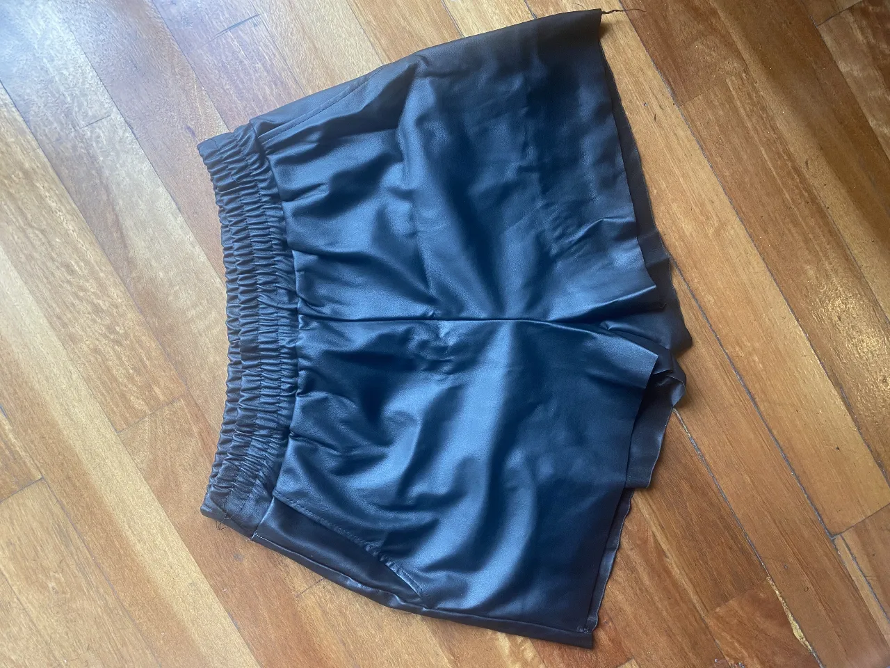 Shorts de cuero sintético negro, tiro alto con elástico en la cintura. Ideales para un look canchero y moderno.