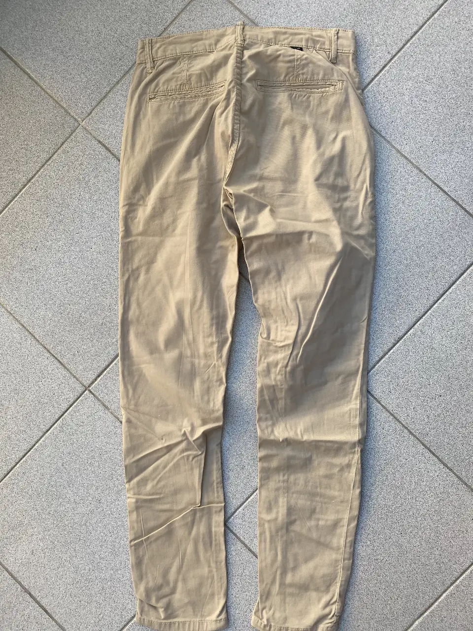 Pantalón chino color khaki para hombre. Corte recto, ideal para un look casual y versátil. Perfecto para combinar con diferentes estilos.