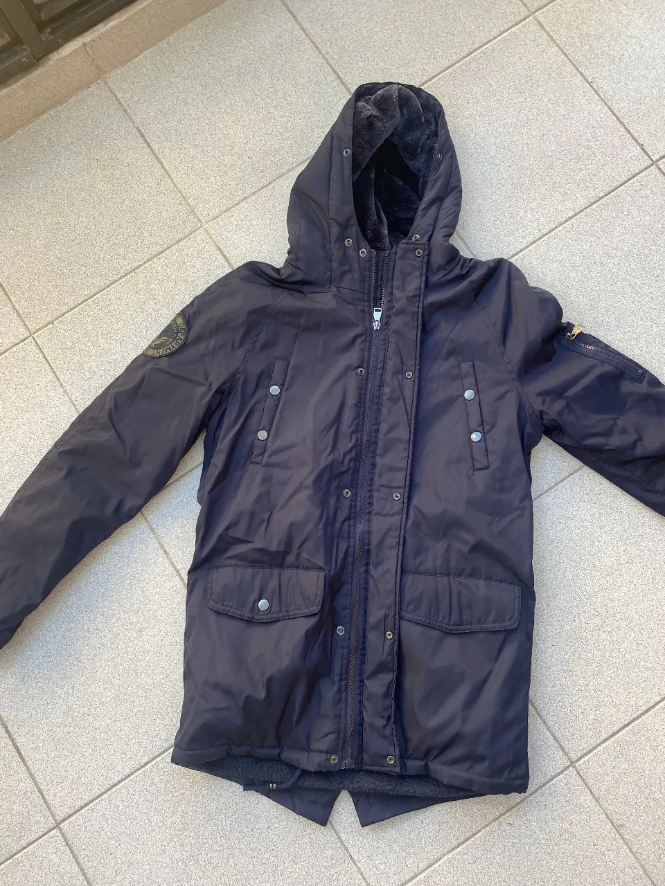 Campera de abrigo para niño, color azul oscuro, con capucha, forro de piel sintética y en su interior polar. Ideal para el invierno, con cierre y bolsillos. Muy abrigada.