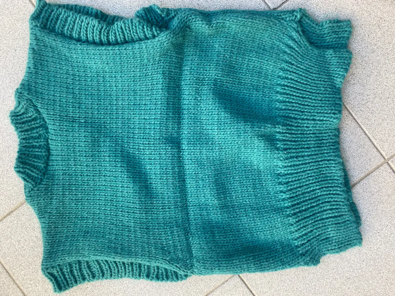 Chaleco tejido de lana, color verde agua. Ideal para usar sobre una camisa o remera en los días frescos. Un básico versátil y cómodo para tu guardarropa.