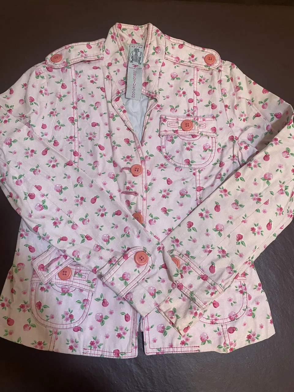 Blaizer corto de mujer Kosiuko con estampado floral en tonos rosas. Posee botones y bolsillos. Ideal para un look casual y femenino. Talle M (chico)