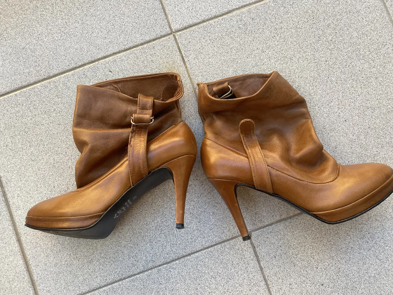 Botines de cuero marrón con taco alto y diseño arrugado en la caña. Ideales para un look elegante y moderno.