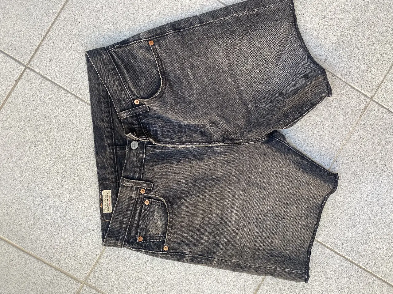 Bermudas de jean negro gastado, ideal para un look casual y moderno. Perfecto para el verano, este bermuda es un básico que no puede faltar en tu guardarropa. Combinalo con remeras, camisas o lo que más te guste.