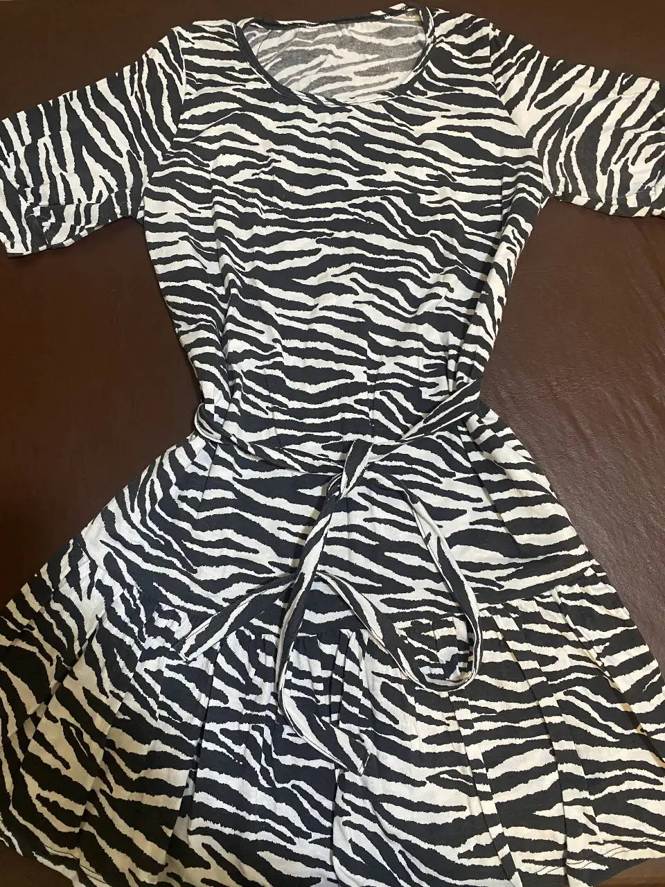 Vestido mini con estampado de cebra, con mangas cortas y cinturón para ajustar la cintura.  Ideal para un look casual y moderno. Talle 1