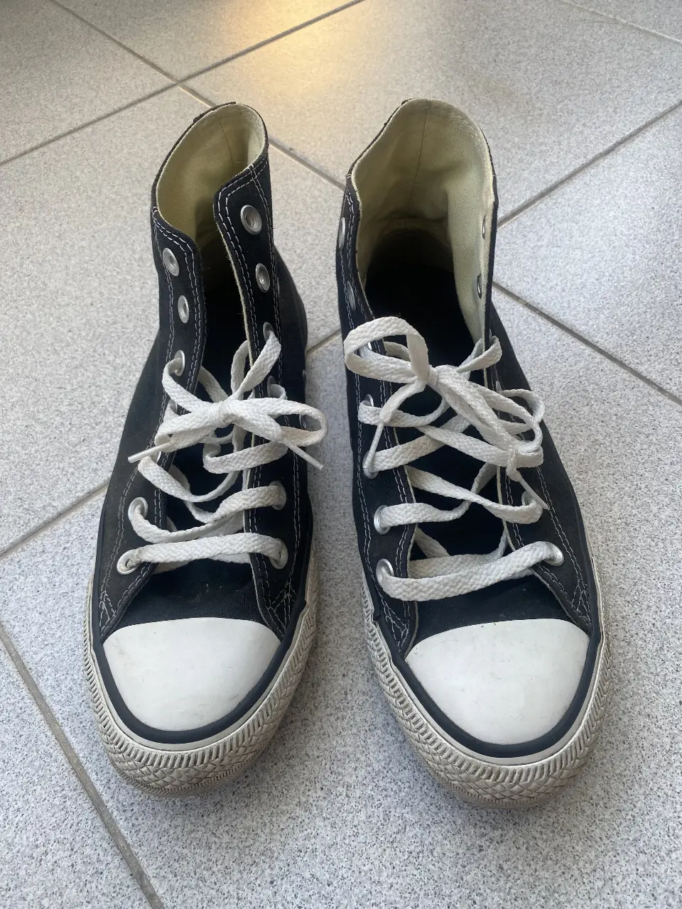 Zapatillas Converse All Star negras de caña alta con puntera blanca. Clásicas zapatillas de lona, ideales para un look casual y urbano. Unisex