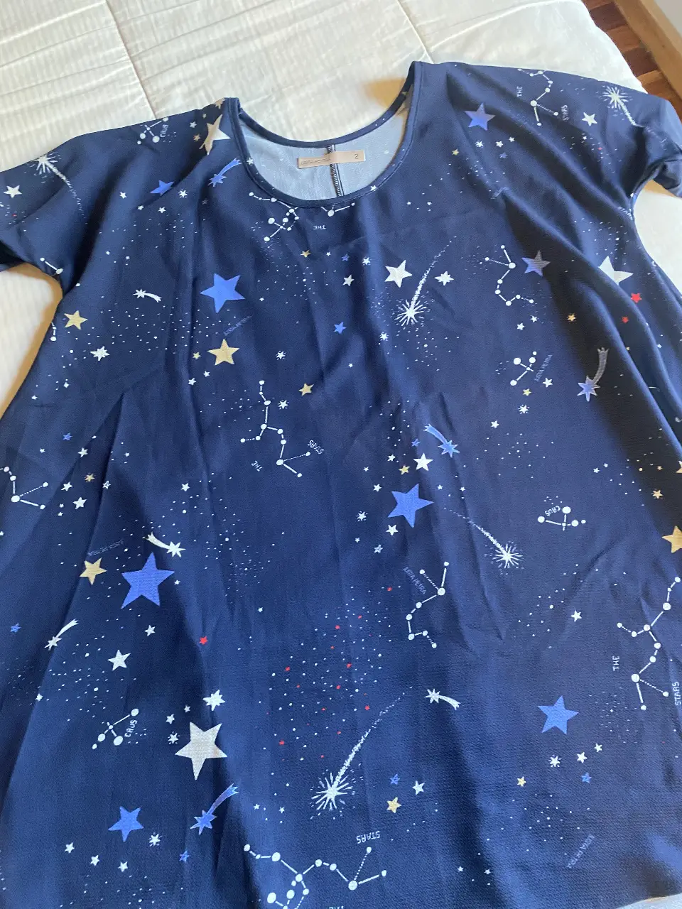Vestido con estampado de constelaciones en tonos azul marino y blanco. Cuello redondo y mangas cortas. Amplio y cómodo. Ideal para un look casual. Talle 2