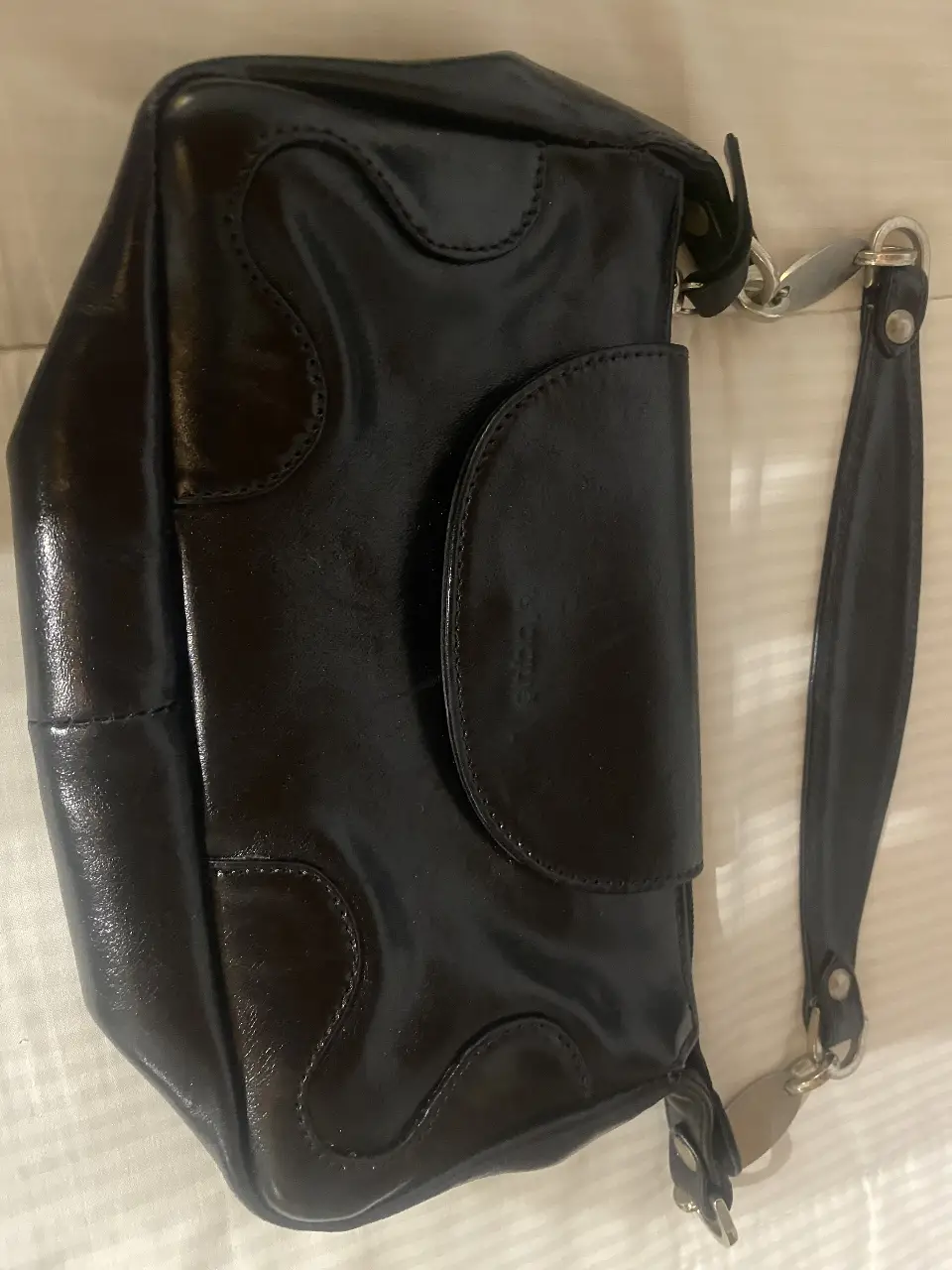 Cartera de hombro negra de cuero con solapa y detalles de costura. Ideal para un look elegante y sofisticado.