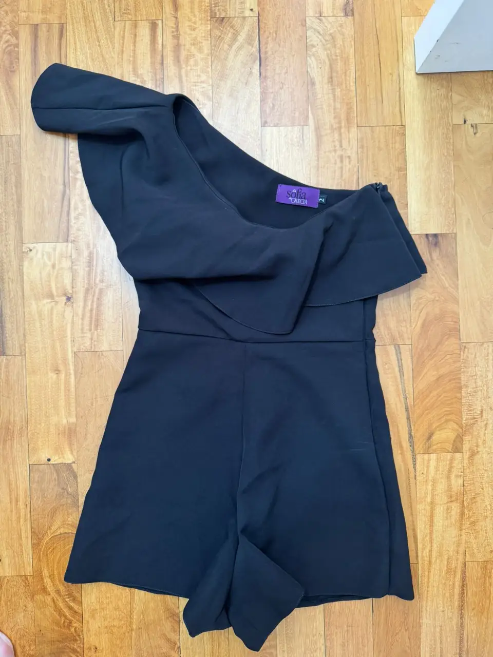 Mono corto negro de un solo hombro, ideal para fiestas o salidas. Diseño elegante y moderno.