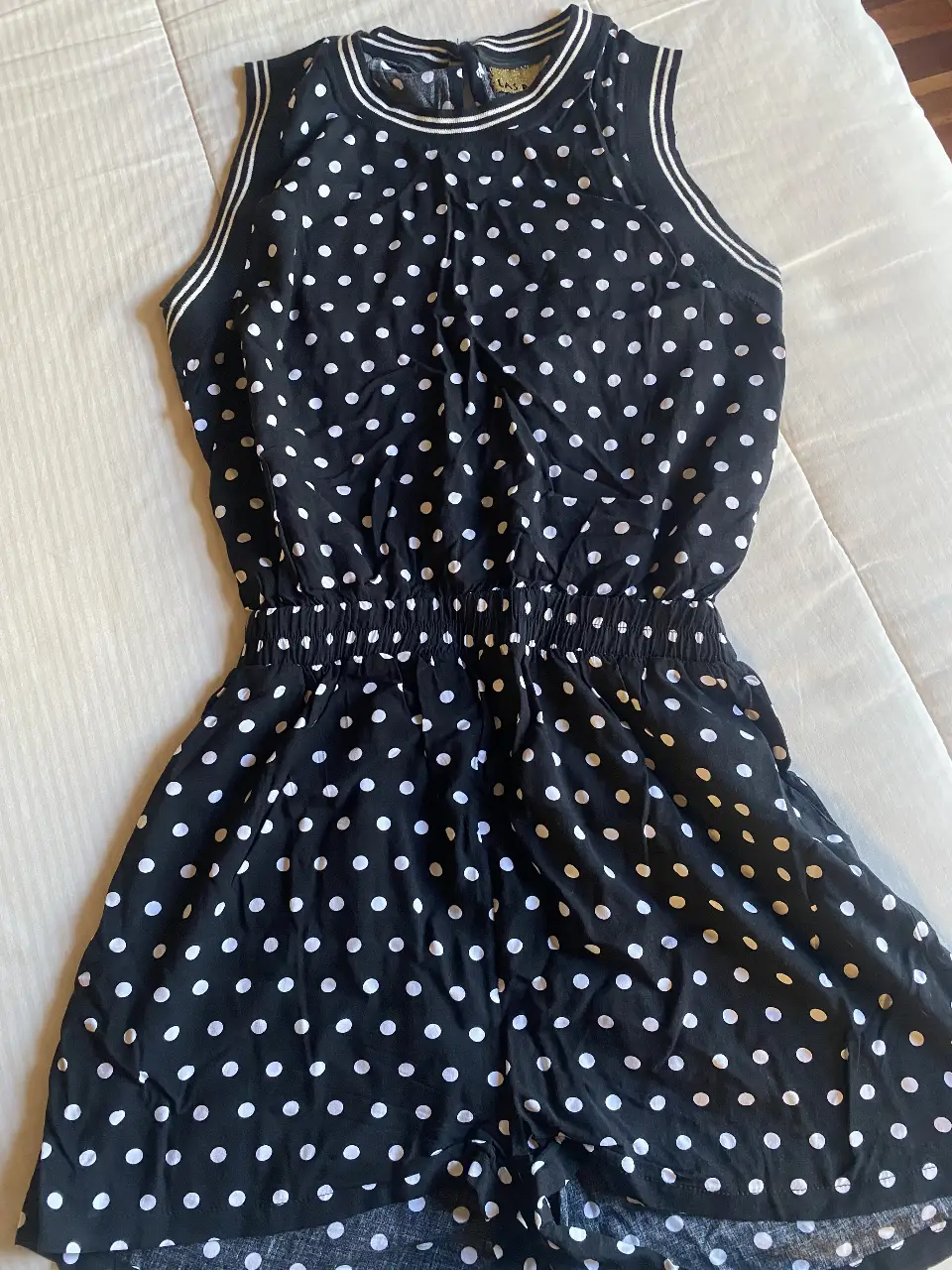 Mono corto negro con lunares blancos. Tiene cintura elastizada y detalles en blanco en el cuello y mangas. Ideal para un look casual y fresco.  Súper cómodo y practico.