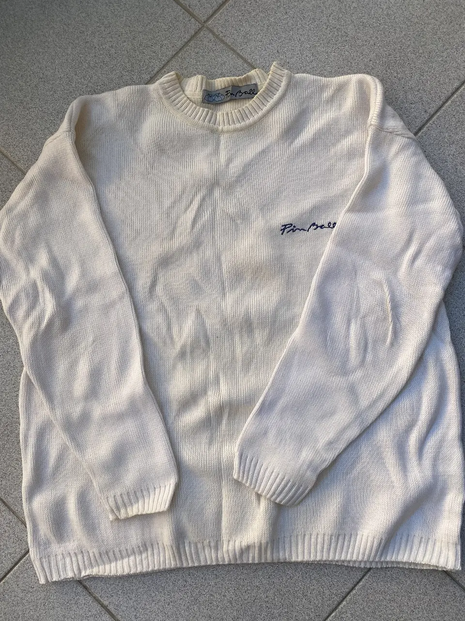 Sweater de mujer e de color beige con detalle de bordado "Pinball" en el pecho y espalda. Diseño clásico y cómodo, ideal para un look casual y relajado. Perfecto para combinar con jeans. Talle M