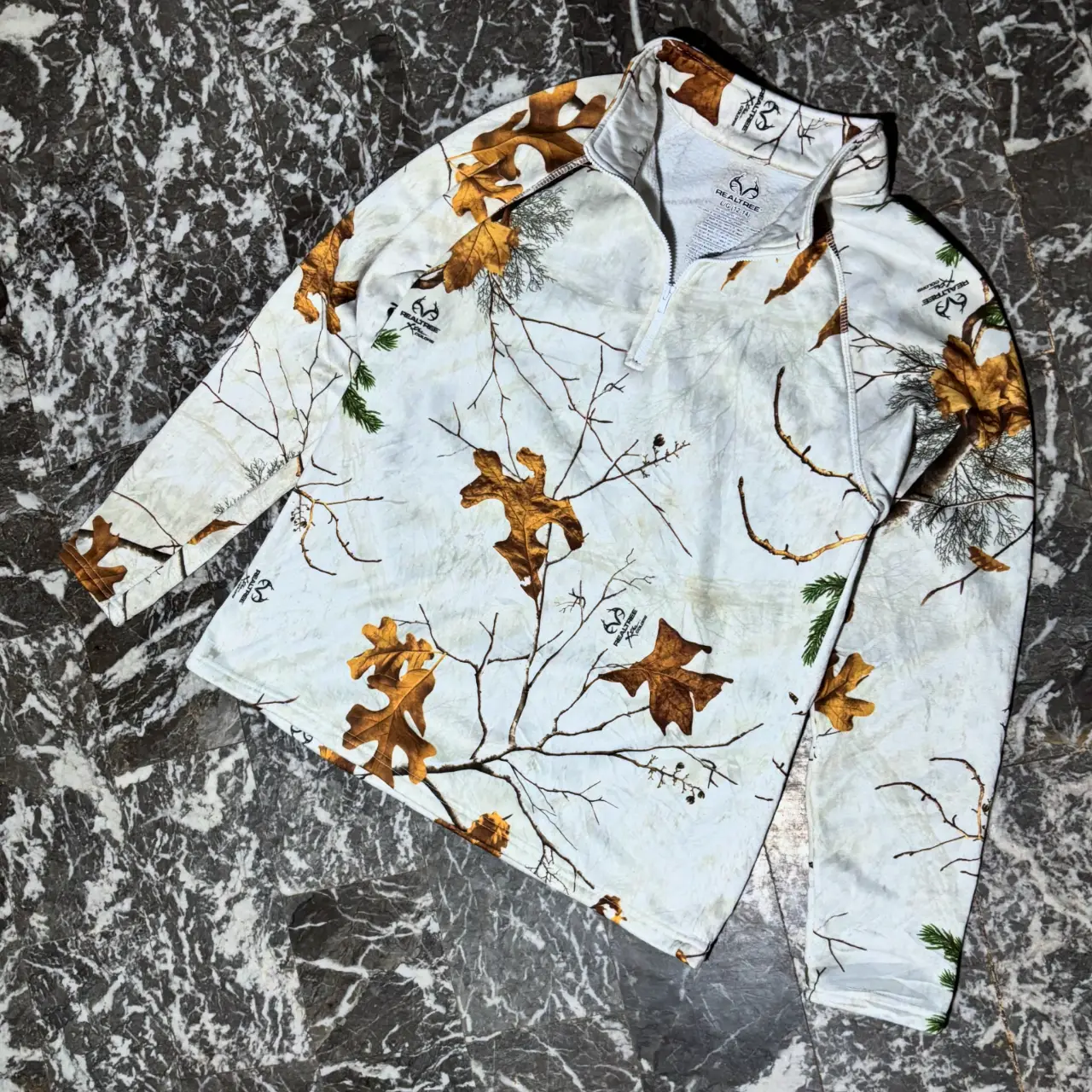 Buzo con cierre y estampado de camuflaje invernal. Ideal para actividades al aire libre o para un look casual y abrigado. Confeccionado con materiales de calidad para mayor comodidad y durabilidad Realtree