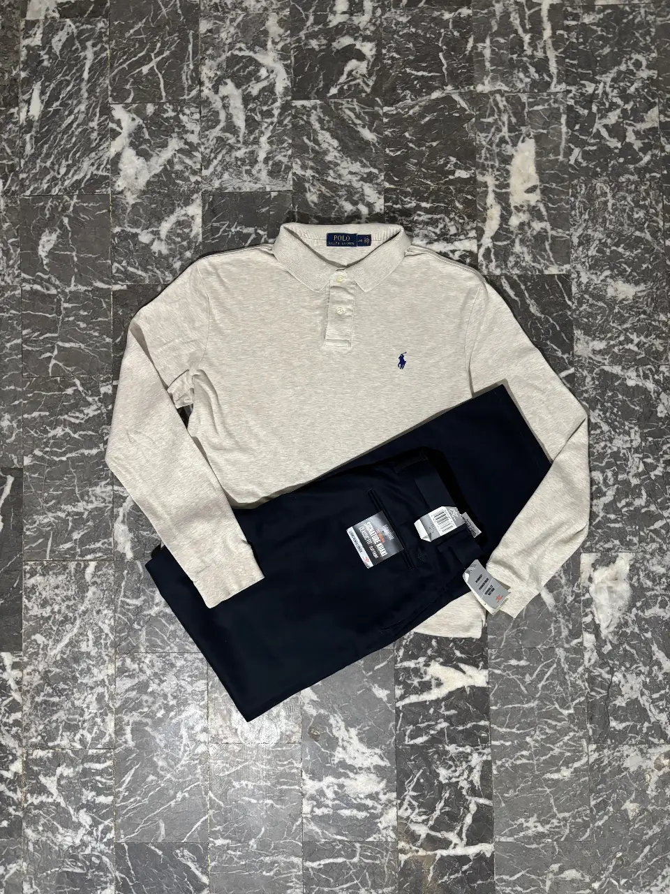 Conjunto Polo Ralph Lauren, compuesto por un sweater polera manga larga color gris con el logo de la marca bordado en azul, y un pantalón chino azul marino. Ideal para un look casual y elegante.