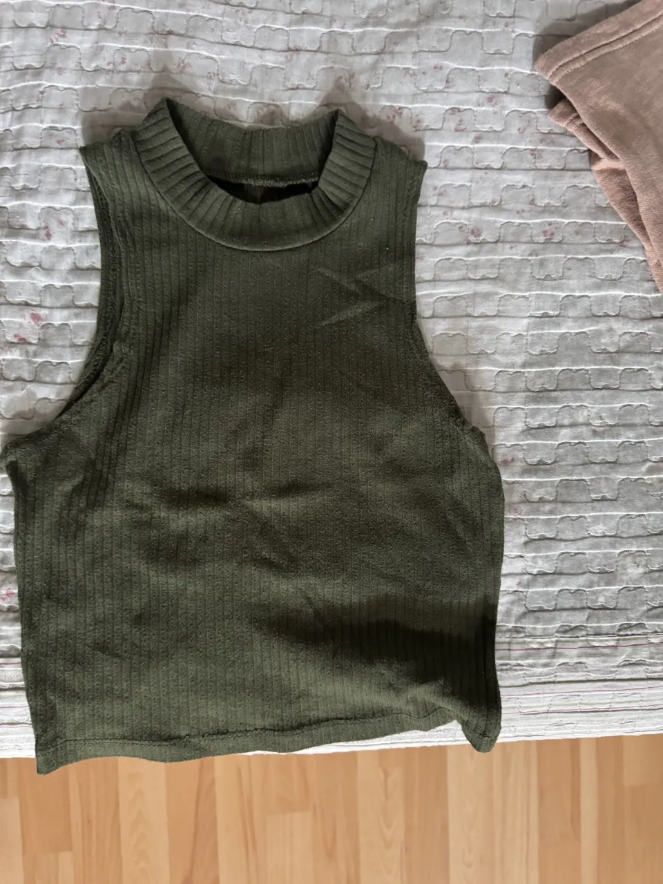 Musculosa de tejido acanalado con cuello redondo alto.