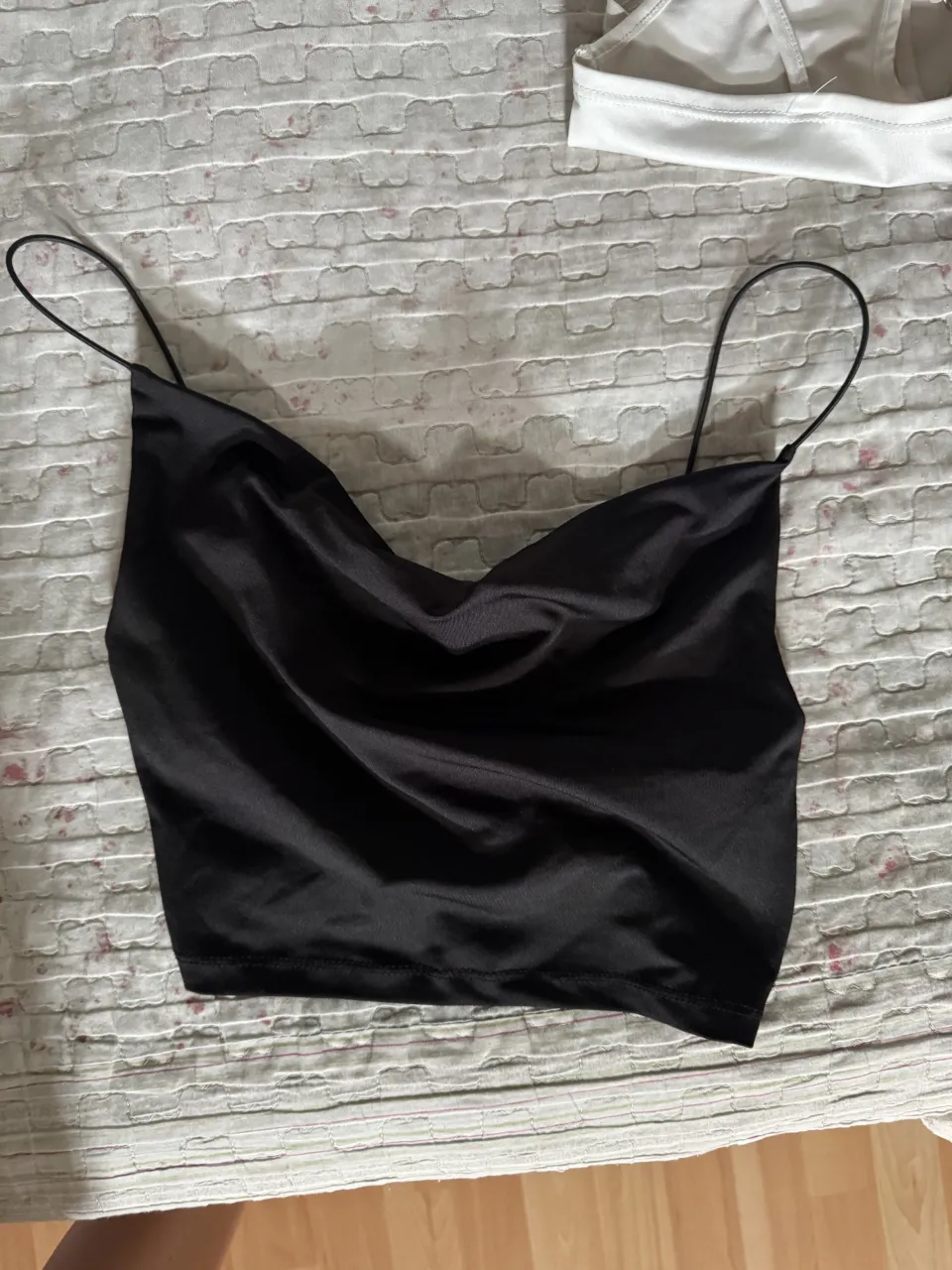 Top negro con breteles finos y escote drapeado.