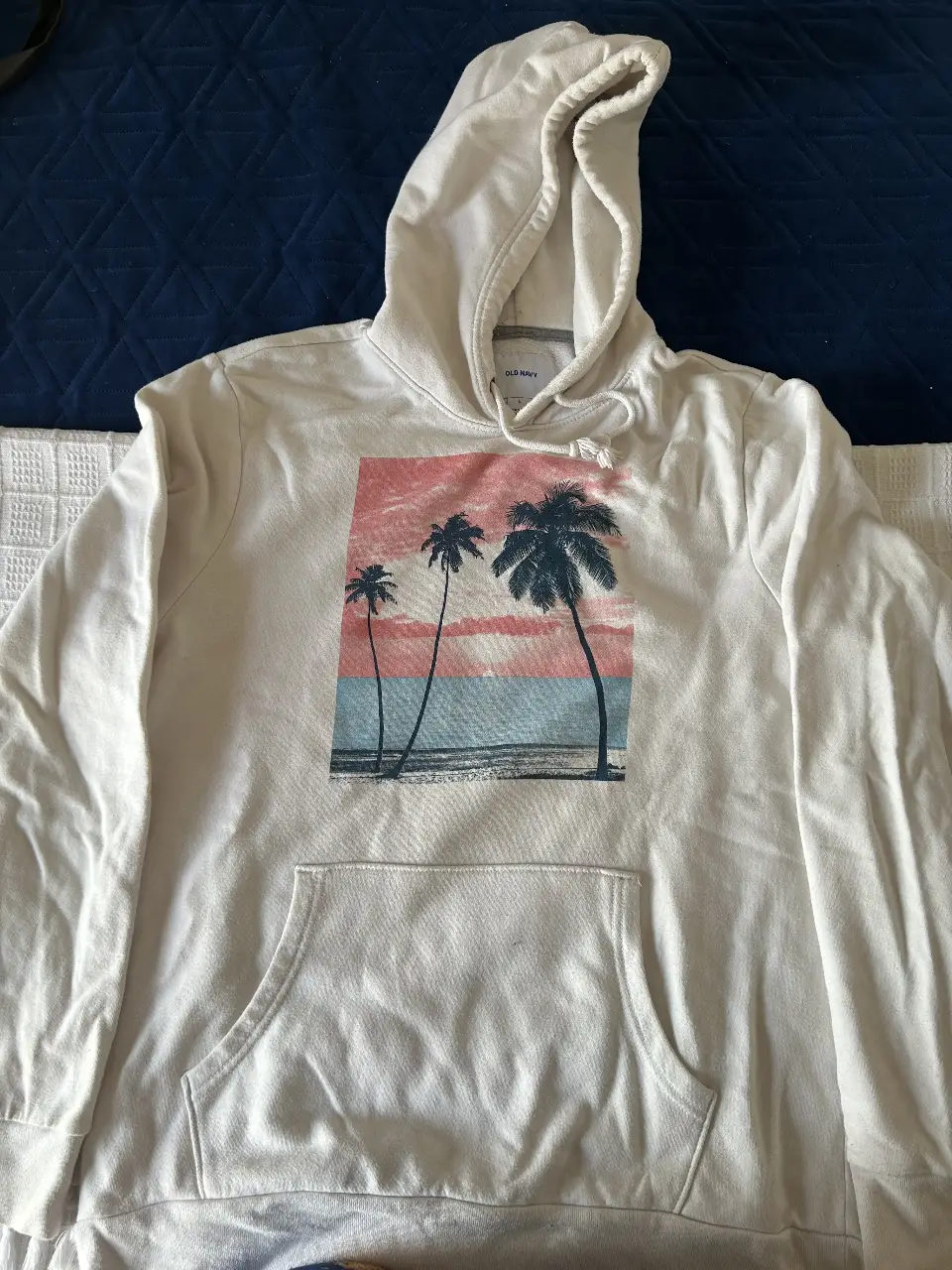 Buzo canguro blanco de Old Navy con estampado de palmeras. Ideal para un look casual y relajado. Tiene  unas manchitas chiquitas 