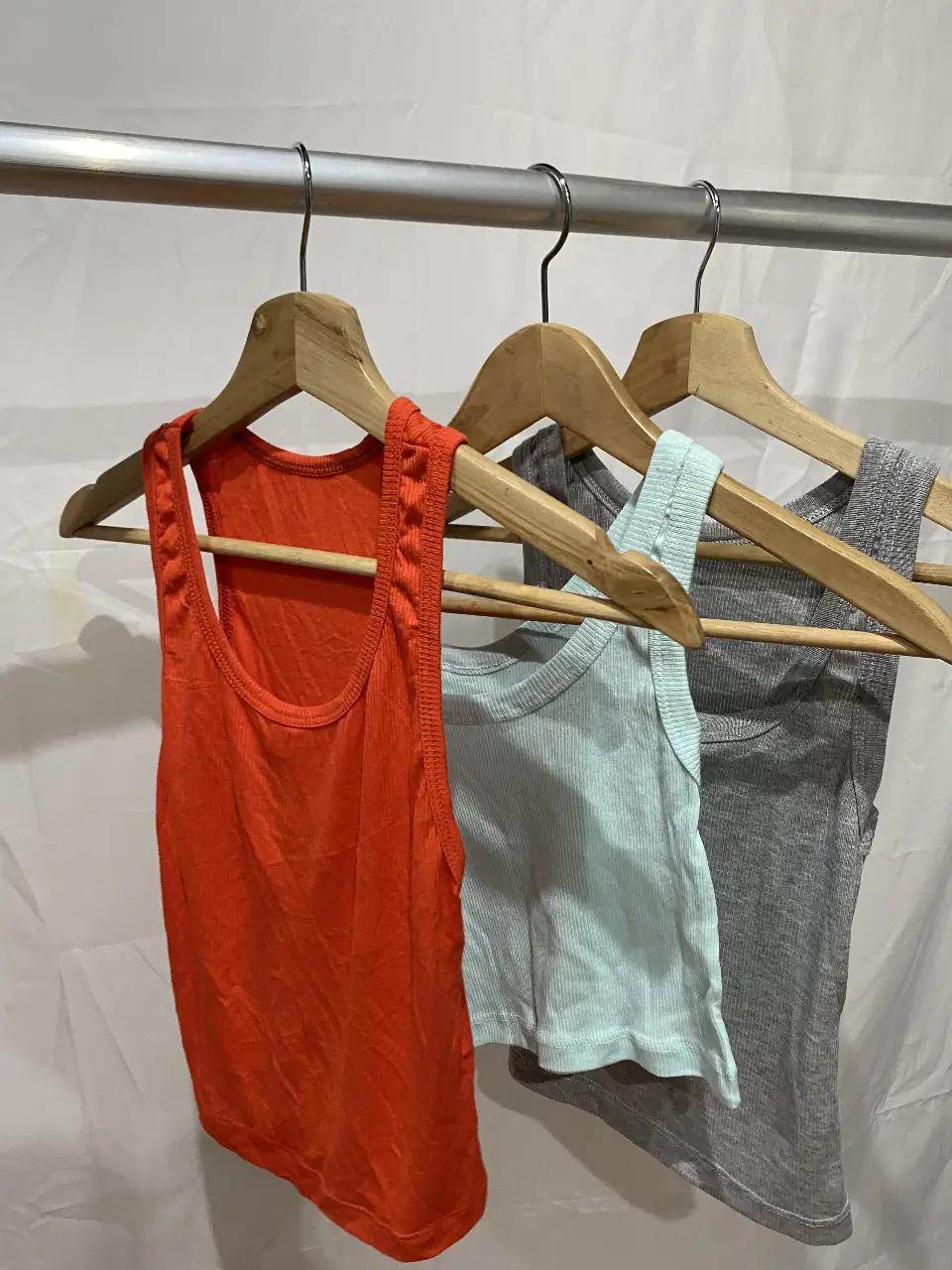 Pack de 3 musculosas de morley. Incluye una musculosa naranja, una celeste y una gris.