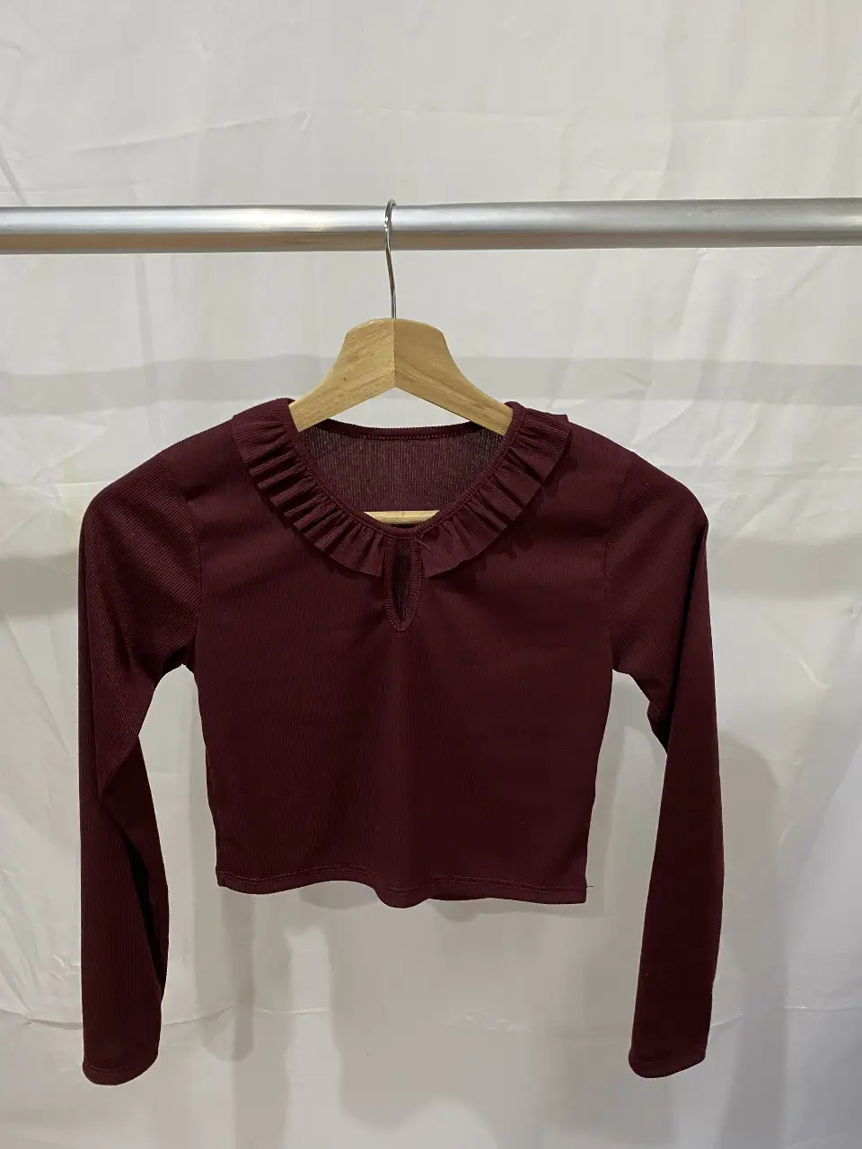 Blusa de manga larga color borgoña con cuello redondo y detalle de volados 
