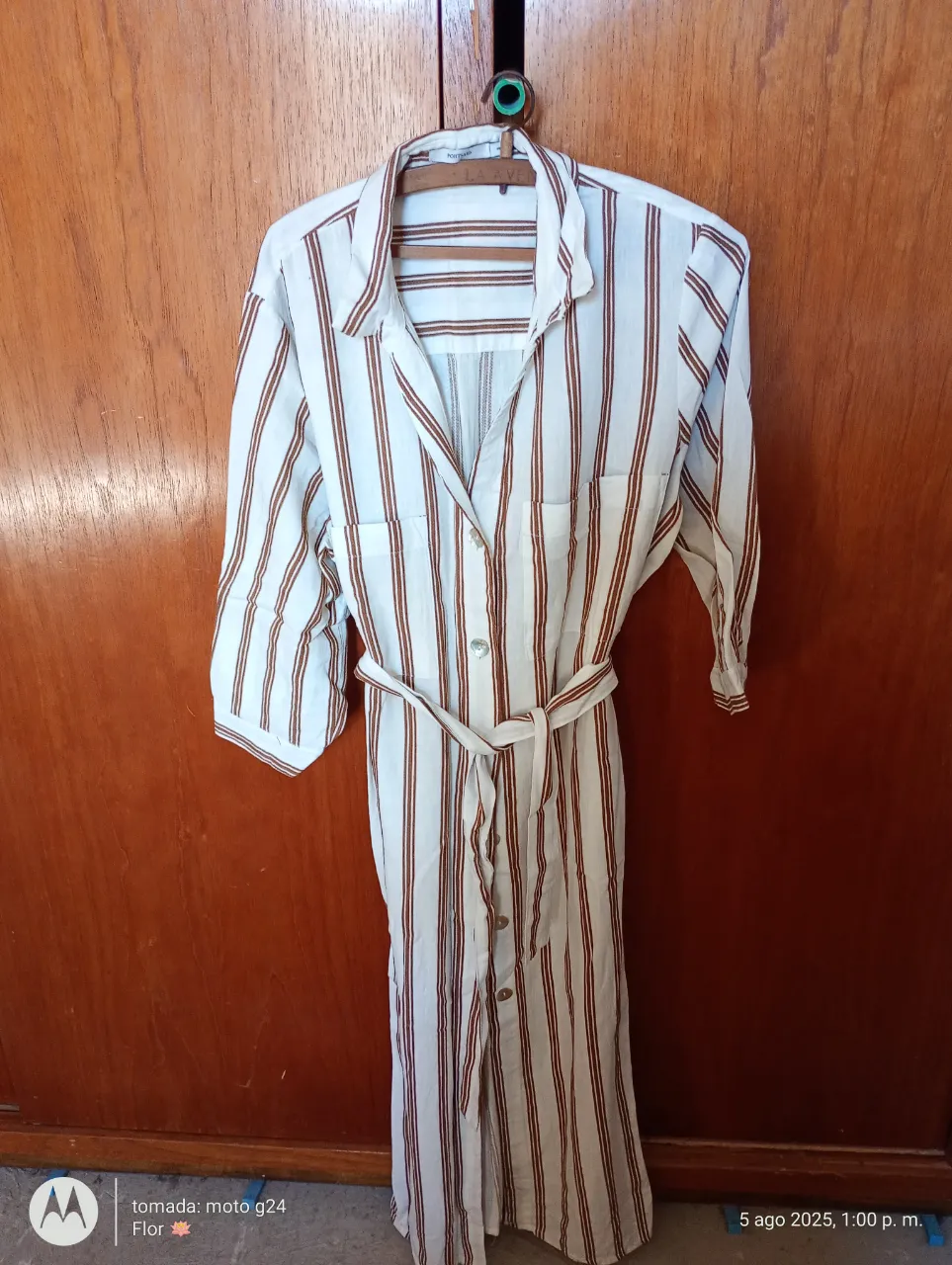 Camisa de vestir a rayas verticales en color blanco y marrón. Con cinturón para ajustar a la cintura, mangas 3/4 y botones frontales. Ideal para un look casual y elegante.