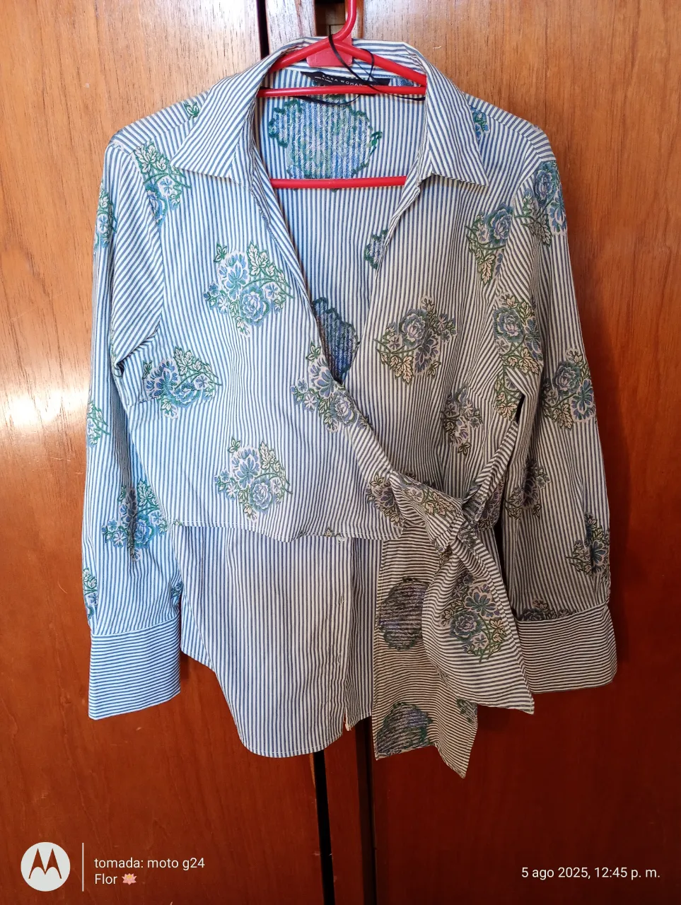 Blusa de mujer Zara Woman con estampado floral y rayas verticales. Diseño cruzado con lazo en la cintura, mangas largas y puños. Ideal para un look elegante y femenino.