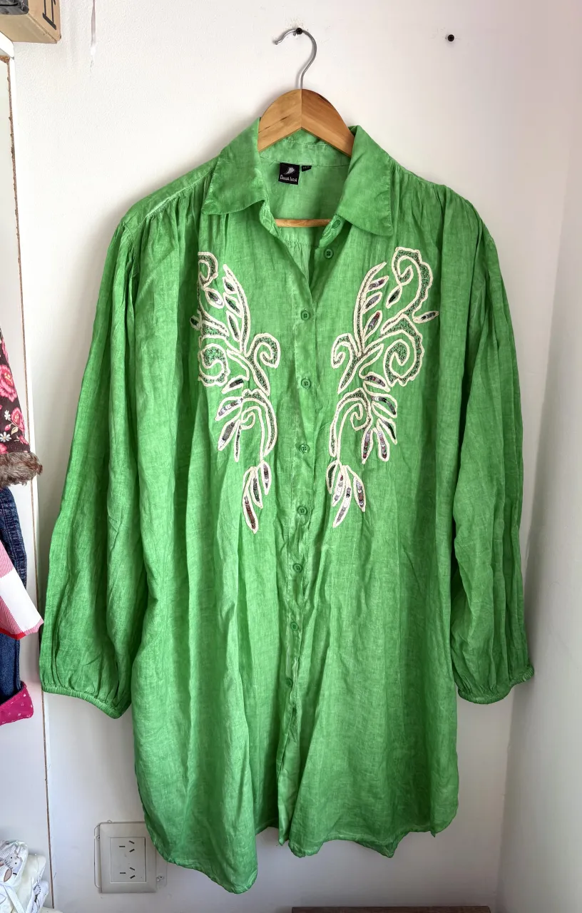 Camisa oversize larga verde vibrante con bordados blancos y detalles de lentejuelas en el frente. Manga larga con puño. Ideal para un look casual y canchero. Sirve como vestido.
Es talle M/L pero es grande y va hasta XL