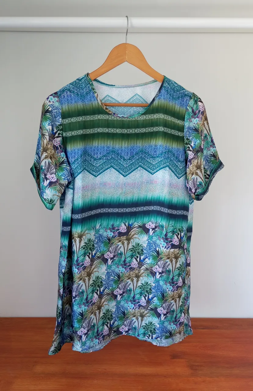 vestido remeron estampado con motivos selváticos y geométricos. Diseño vibrante en tonos verdes y azules, ideal para un look fresco y moderno.