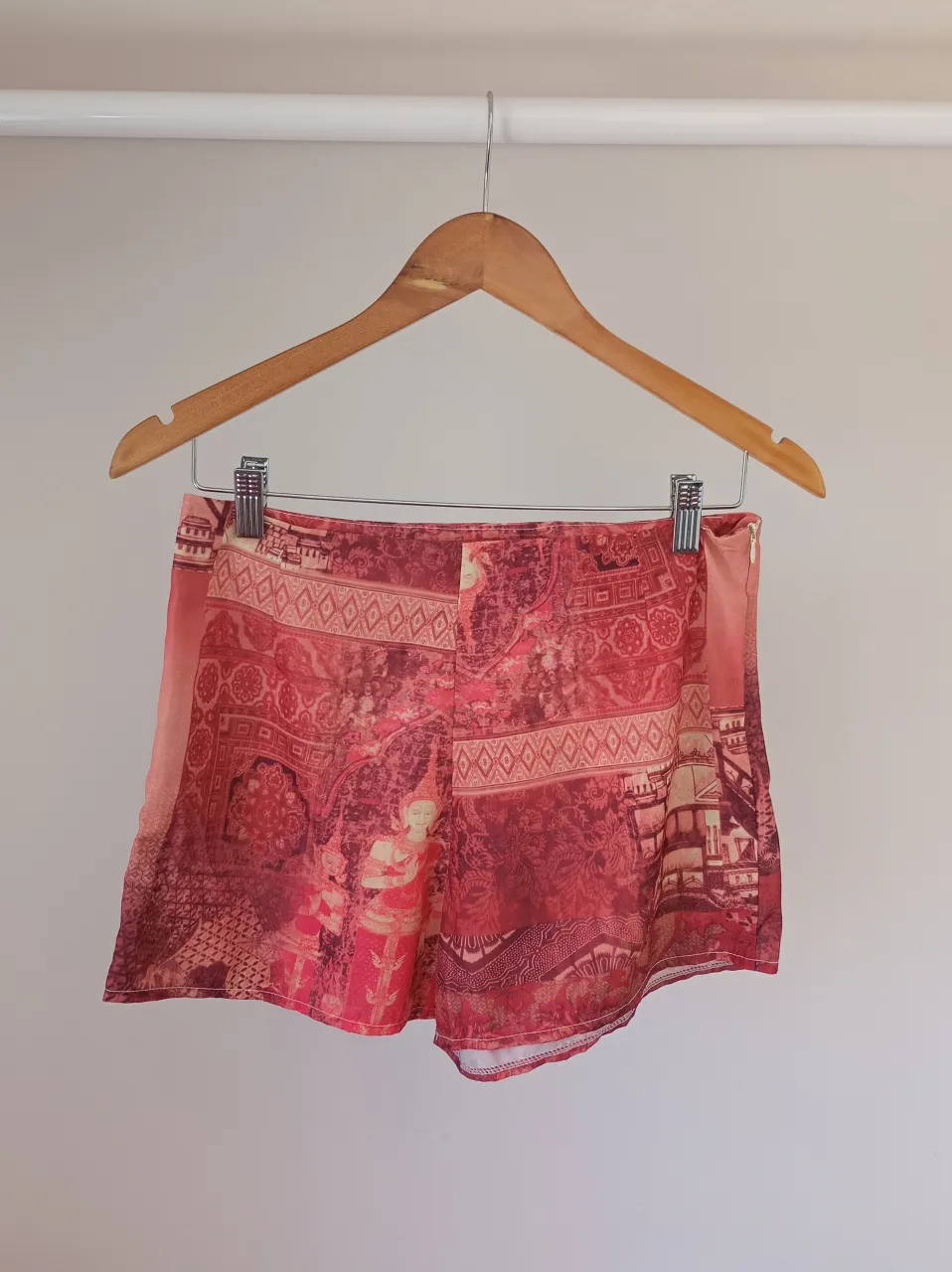 Shorts de seda con estampado de paisajes y figuras orientales en tonos rojos y rosas. Poseen cierre lateral.