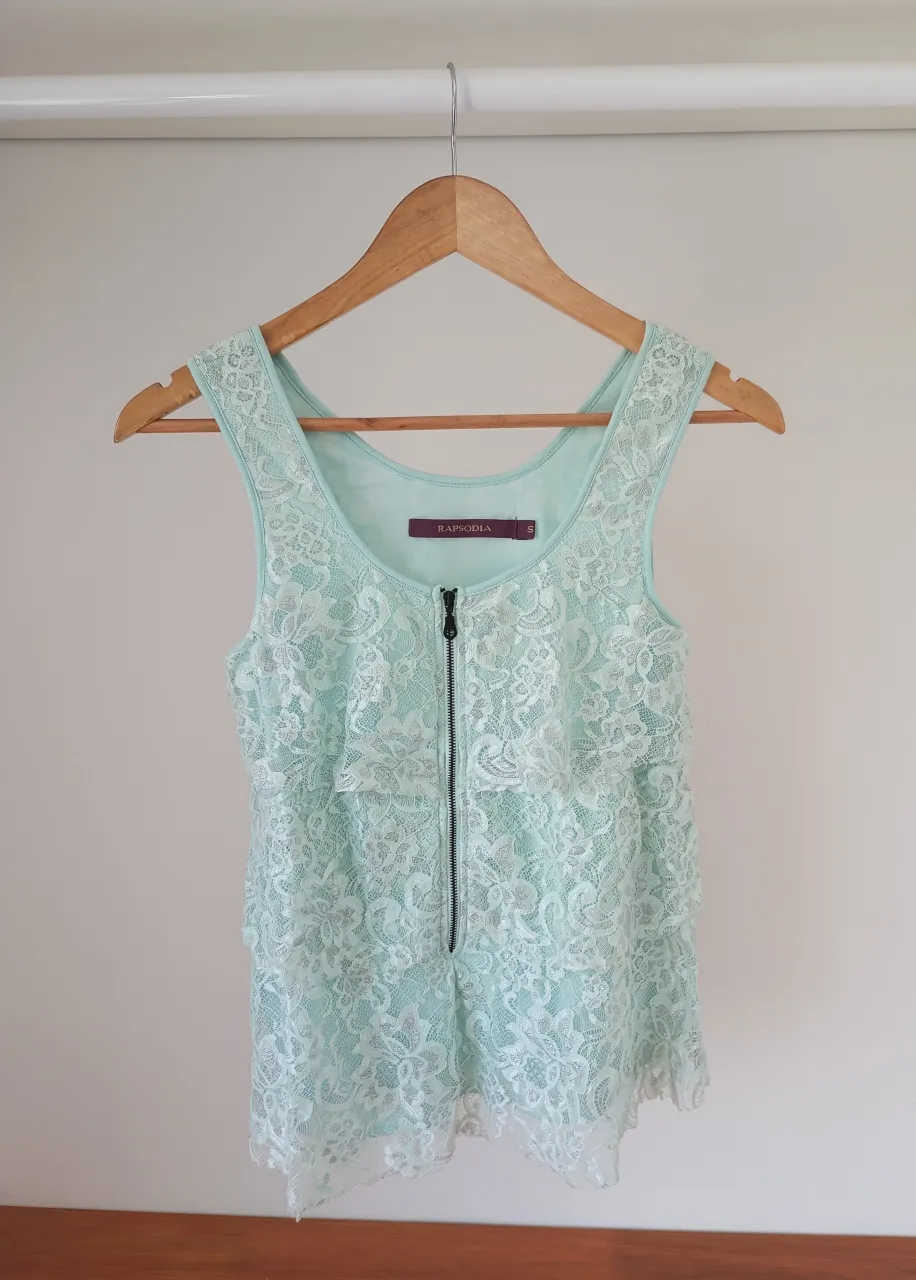 Top de encaje color menta con volados y cierre al frente. Ideal para un look canchero y femenino.