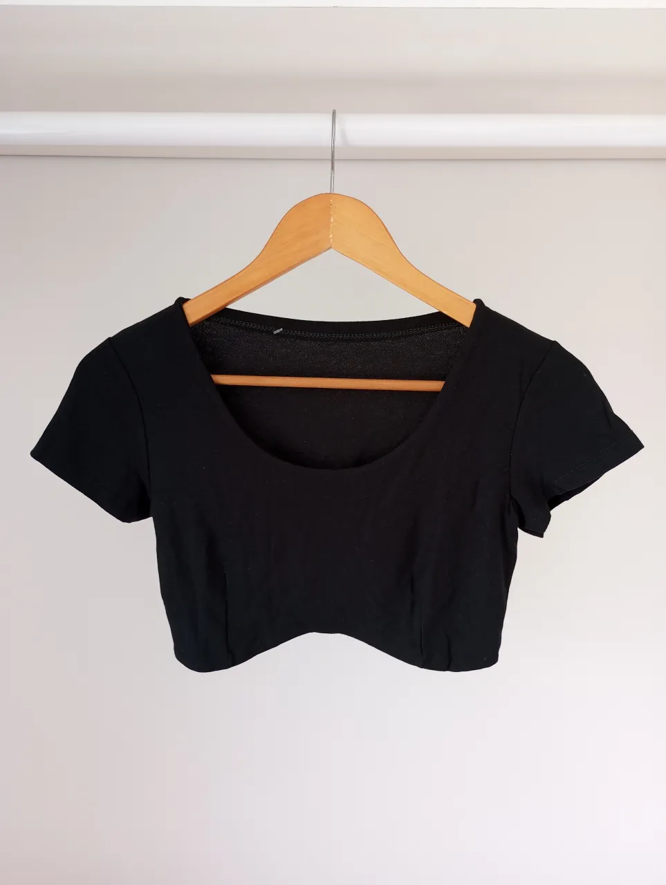 Top negro de manga corta, escote redondo y corte al cuerpo. Ideal para un look casual o deportivo.