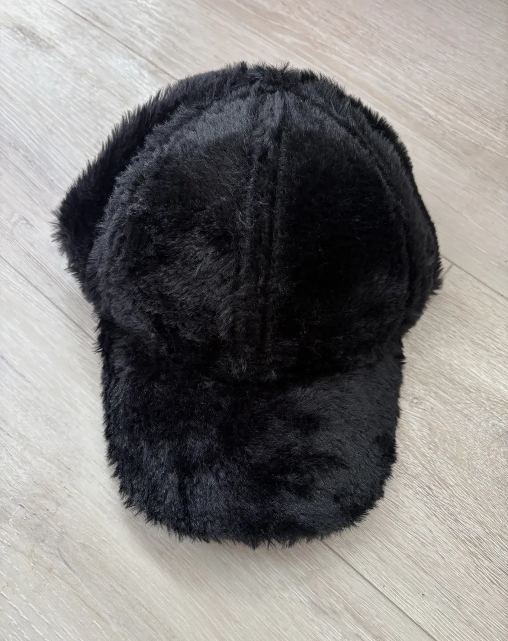 Gorra de pelo sintético negra, súper suave y calentita. Ideal para darle un toque canchero y original a tus looks de invierno.