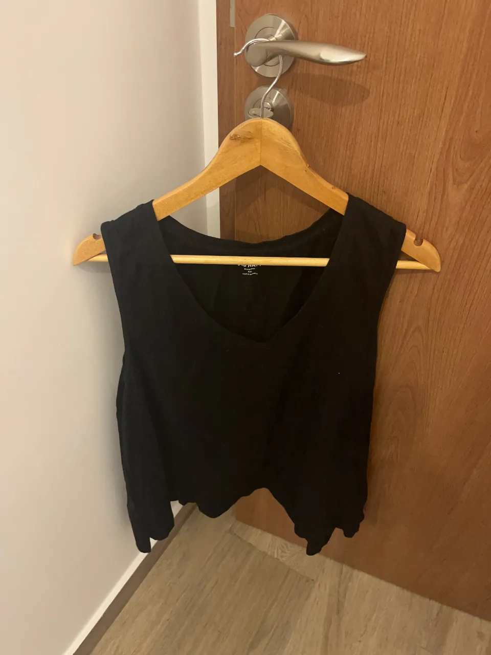 Musculosa negra escotada, ideal para un look casual y fresco. Perfecta para combinar con shorts o jeans.