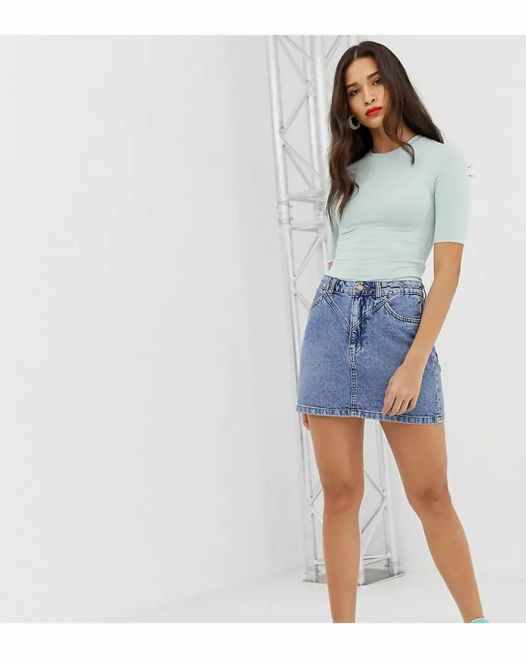 Pollera vaquera de jean azul, con detalles en la cintura y bolsillos delanteros y traseros. Ideal para un look casual y moderno. 