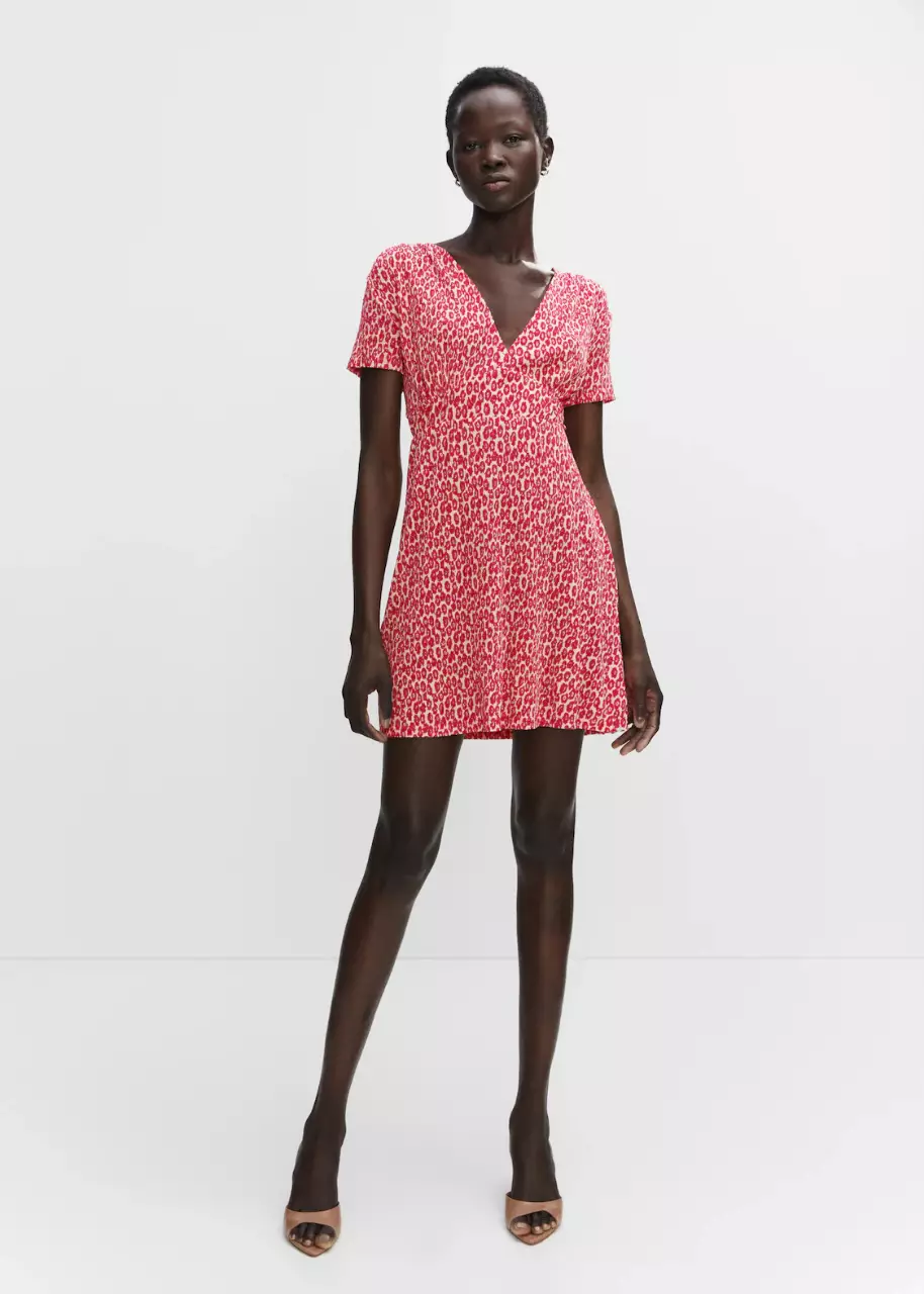 Vestido mini de mujer, con estampado floral en tonos rojos y blancos. Corte en V y mangas cortas. Ideal para un look fresco y casual.  Diseño evasé.  De Mango España