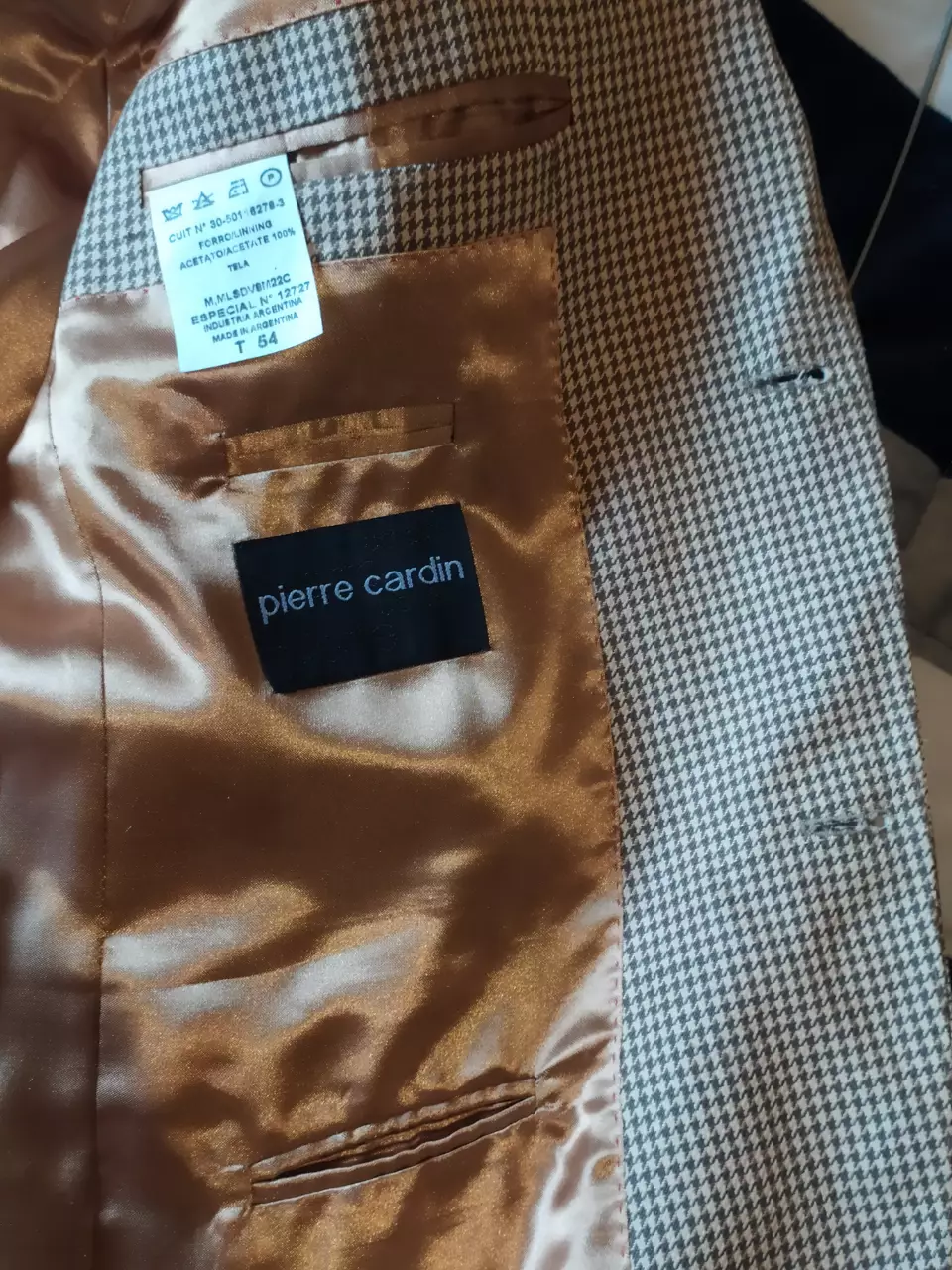 Elegante blazer Pierre Cardin confeccionado en un tejido de patrón de espiga en tonos marrones. Ideal para un look formal o semi-formal. Con forro interior satinado y detalles de calidad.   