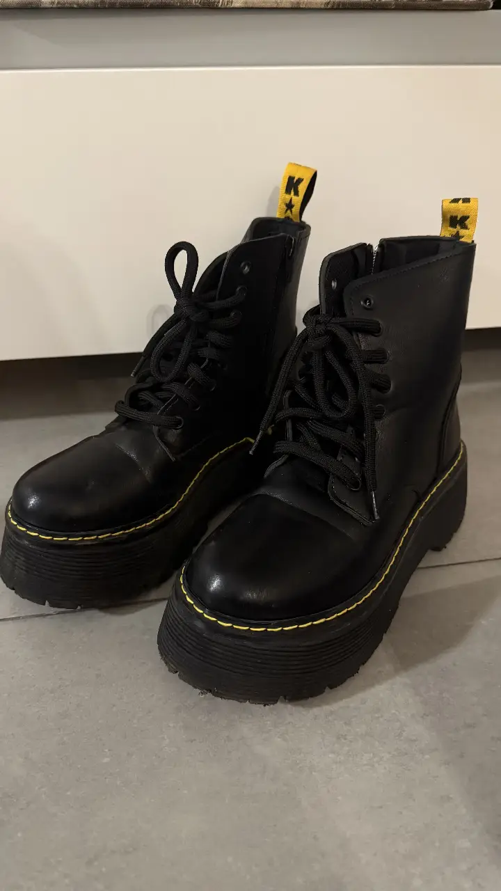 Borcegos negros con suela gruesa y costuras amarillas. Detalles de lengüeta amarilla con logo. Incluye cordones originales y adicionales. Ideales para un look urbano y moderno.