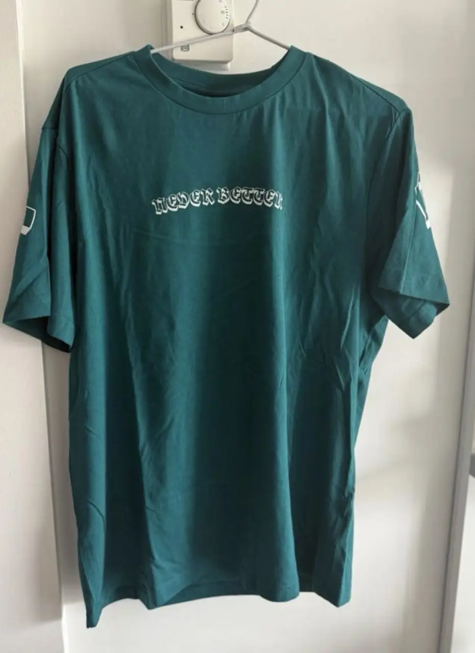 Remera de hombre de color verde oscuro con estampado "NEVER BETTER" en la parte delantera y trasera. Corte regular fit, ideal para un look casual y moderno. Confeccionada en algodón suave y cómodo, perfecta para el uso diario.