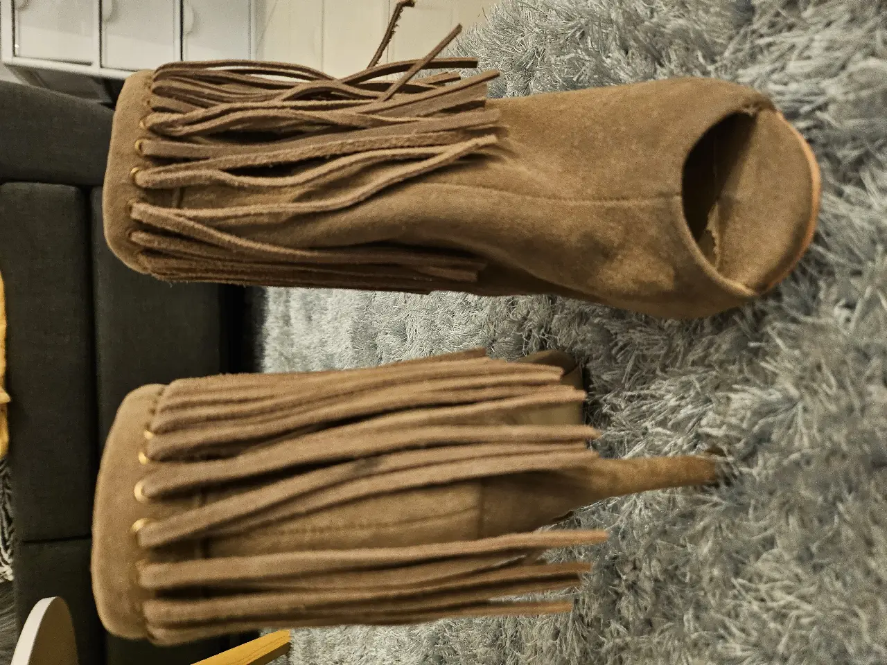 Botines de gamuza marrón con flecos, ideales para un look boho chic. Diseño con punta abierta y cierre lateral. Perfectos para combinar con faldas o jeans.