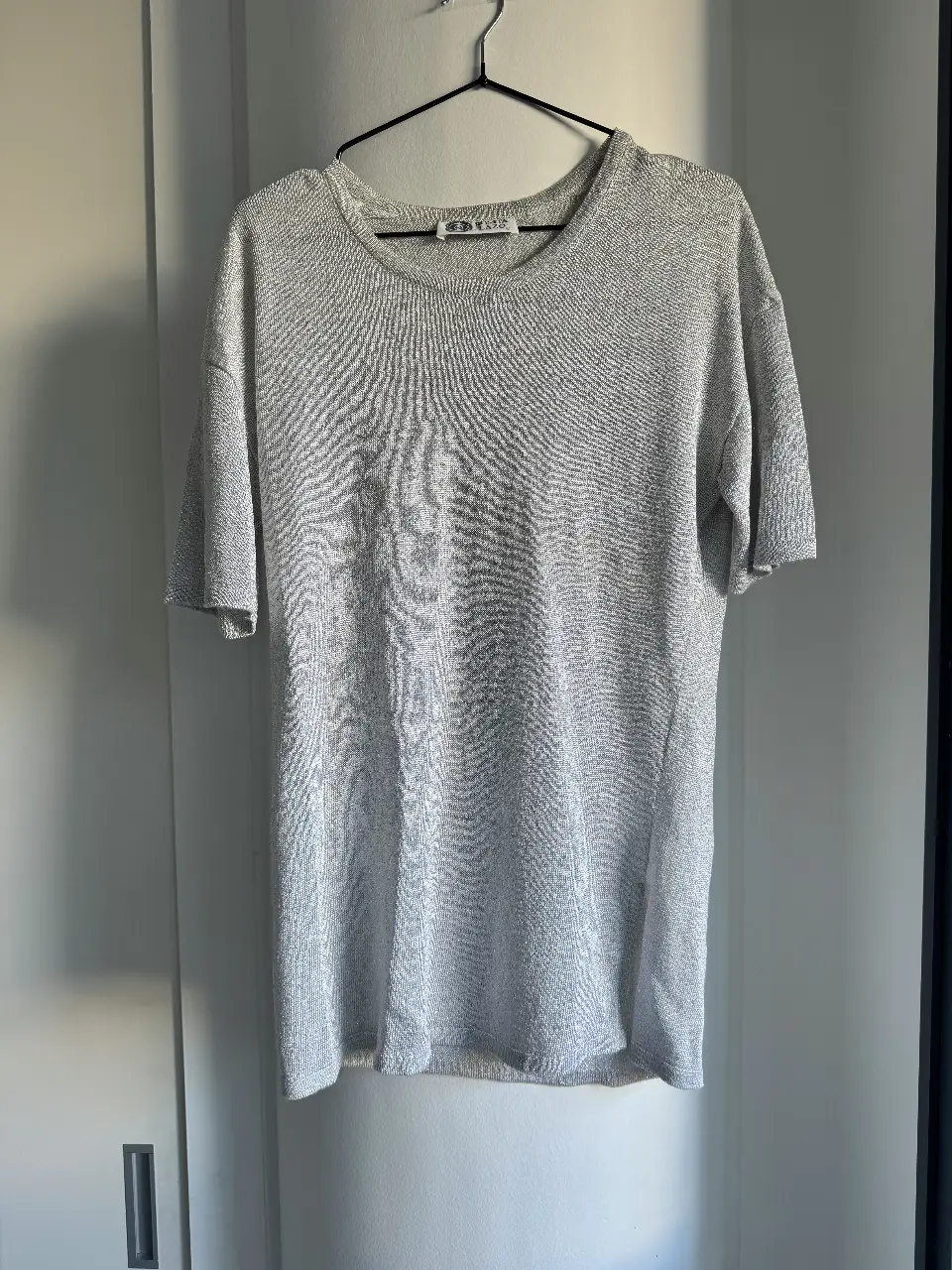 Remera/remerón hermoso manga corta vintage, de tejido brillante plateada. La tela creo que es lurex pero NO PICA🤍Corte oversized, depende tu talle podés usarla como remera o vestido. Corte recto. Medidas: cintura 46cm, axila a axila 52cm, largo 72cm