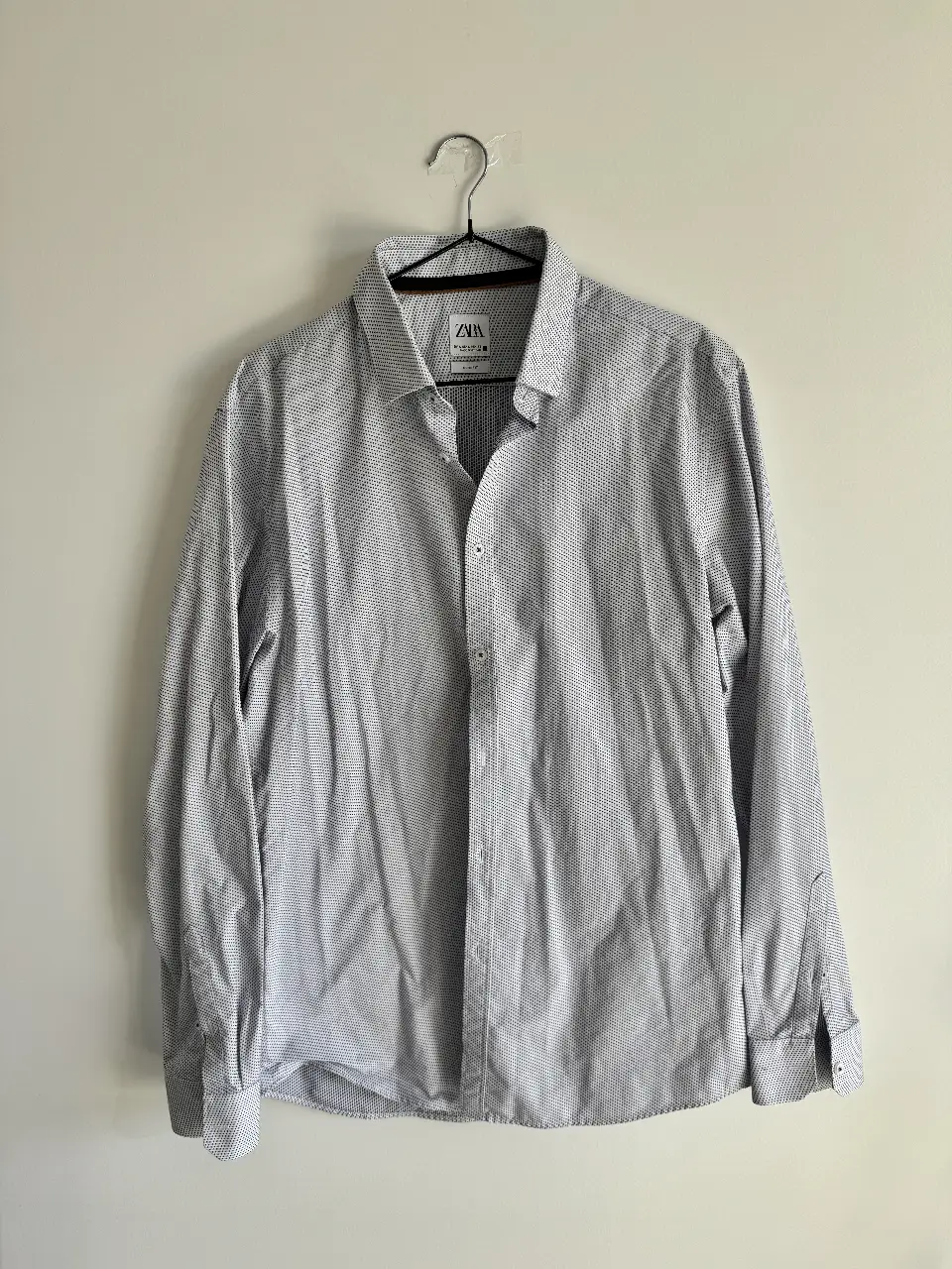 Camisa Zara manga larga, con estampado de puntos en color azul sobre fondo blanco. Corte slim fit, ideal tanto para un look casual o semi formal, como para usar en un casamiento con un buen traje. Medidas: hombro a hombro 47cm, largo frente 76cm, largo espalda 78cm, largo mangas 66cm
