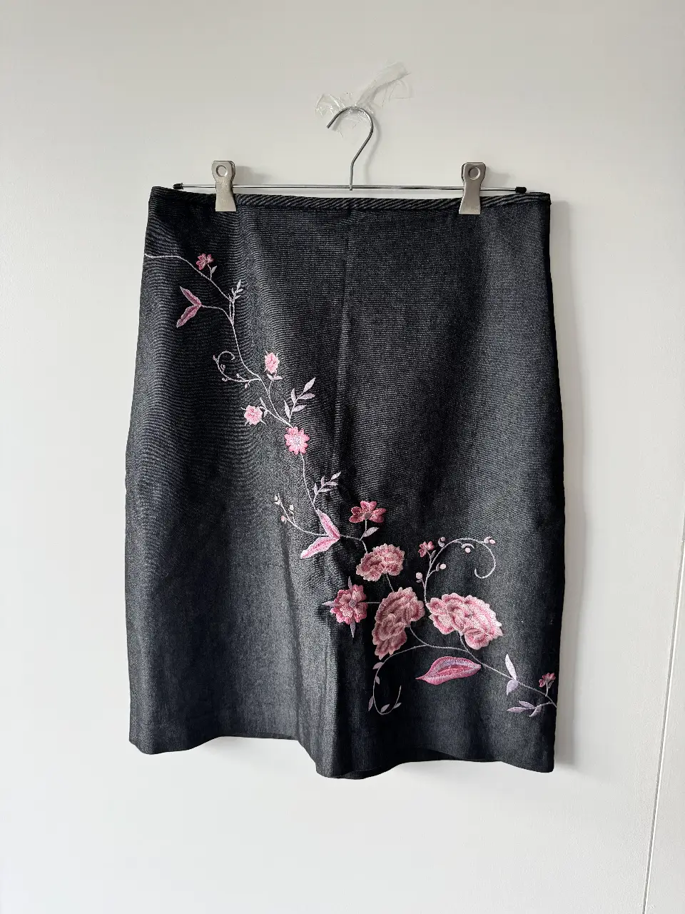 Falda/pollera de jean negro con bordado floral en rosa. Corte a la rodilla (tipo lápiz) y cierre trasero. Tela súper fresca, cero pesada. Es hermosa e ideal para un look elegante y femenino, o hasta casual con una básica blanca💕Medidas (tomadas en plano): cintura 41cm, cadera 51cm, largo 60cm. 