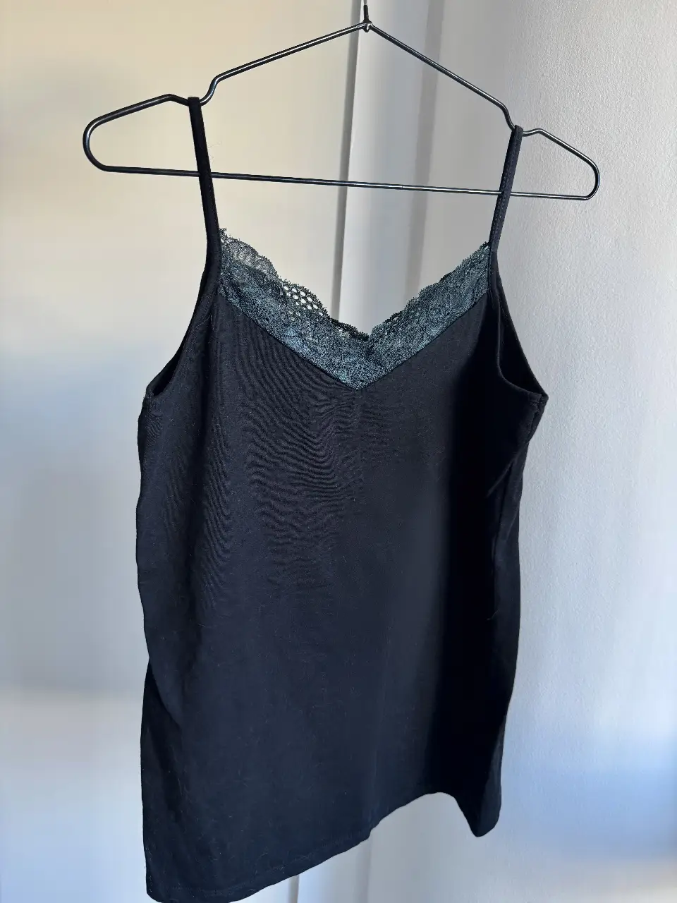 Top negro con detalle de encaje en el escote. Ideal para combinar con jeans o faldas para un look casual y moderno. Perfecto para salir o usar en el día a día. Marca Sacks. Medidas: ancho 40cm, alto 59cm (incluye breteles). La tela tiene elasticidad así que va para un XL también. 