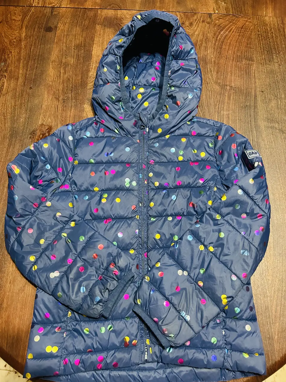 Campera de pluma para niña, azul marino con estampado de lunares multicolores. Con capucha, cierre y etiqueta de la marca GAP. Ideal para el invierno. talle M 