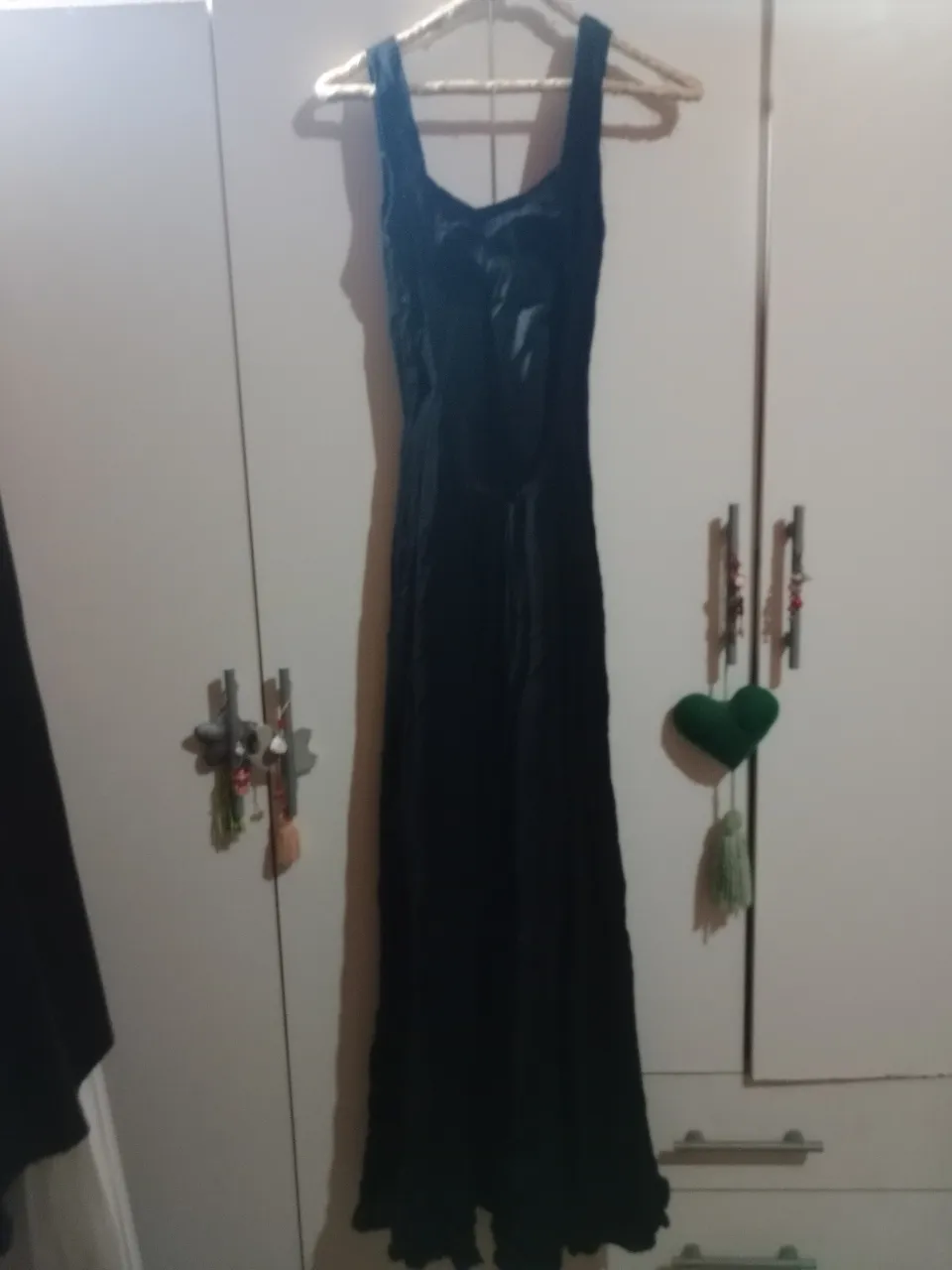 Vestido largo negro, con tirantes anchos y escote pronunciado. Cierre en la espalda.