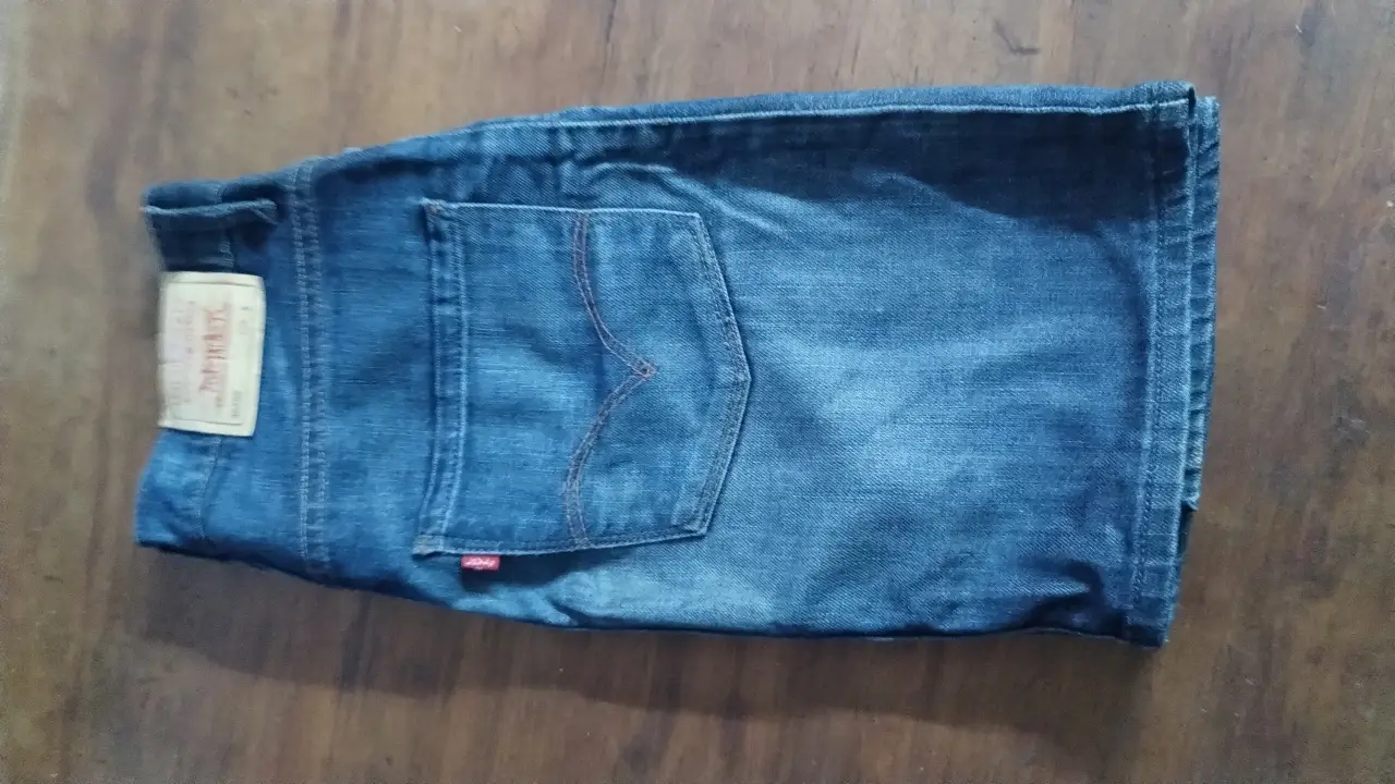 Jeans rectos de hombre, azul oscuro, con etiqueta de la marca Levi's. Bolsillo trasero con costura en forma de arco.
