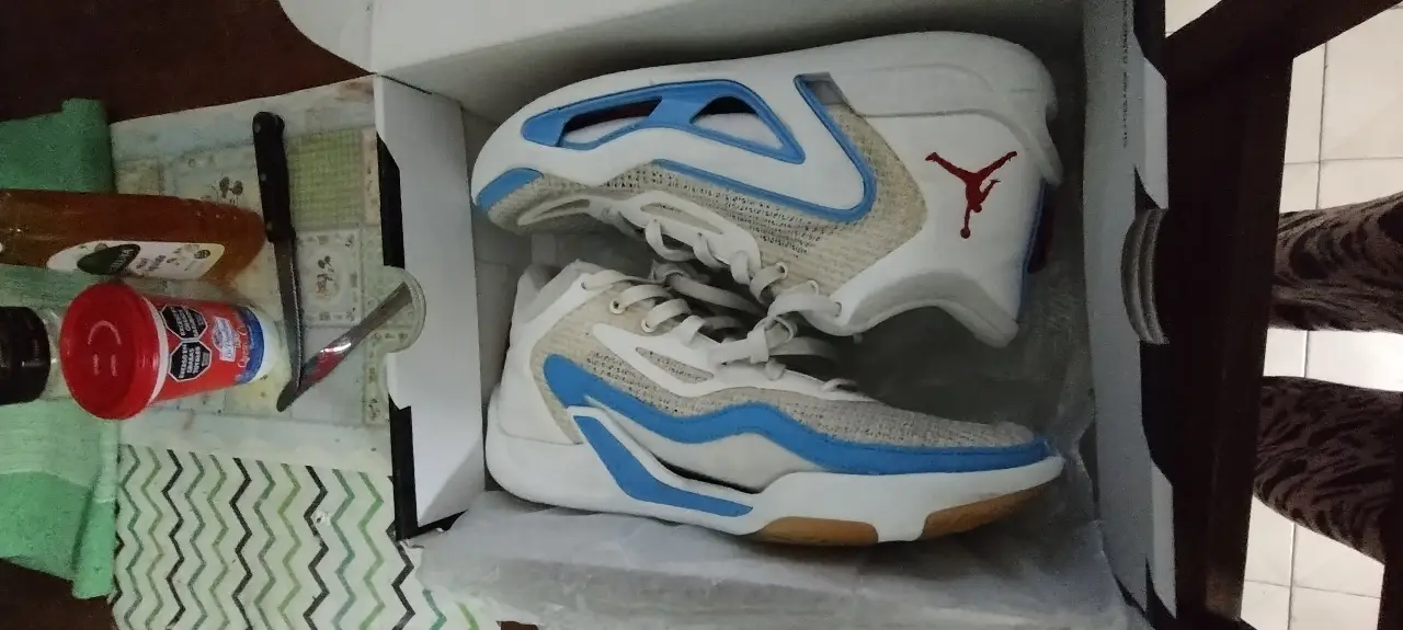 Zapatillas de basquet Jordan Tatum 1, blancas con detalles en celeste y el logo de Jordan en rojo. Diseño moderno y cómodo, ideales para la cancha.