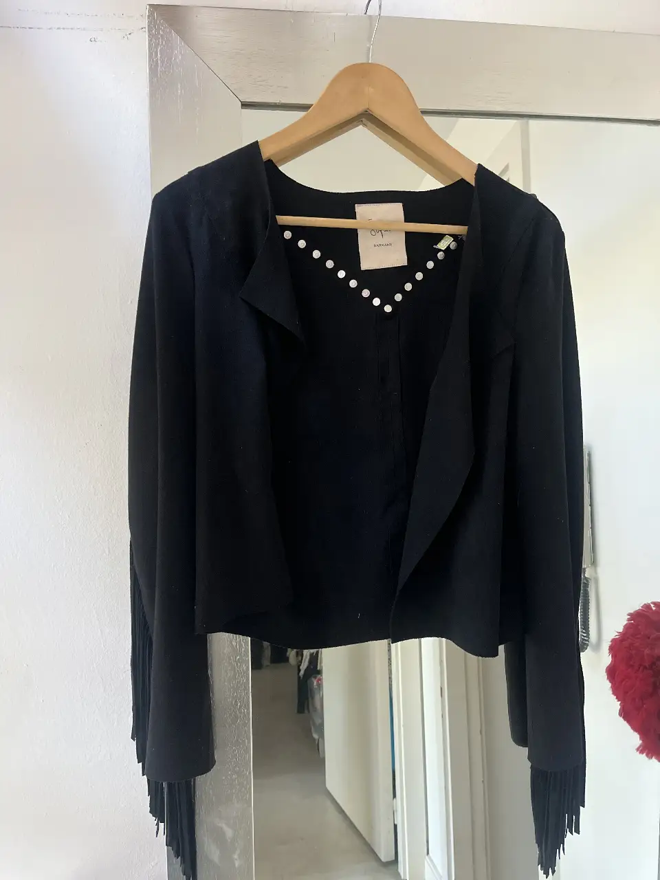 Campera negra de gamuza con flecos en las mangas y detalles de tachas. Estilo biker, ideal para un look rockero y canchero.