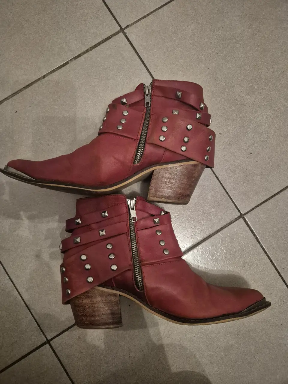 Botines rojos de cuero con detalles de tachas plateadas y cierre lateral. Ideales para un look rocker y con estilo.