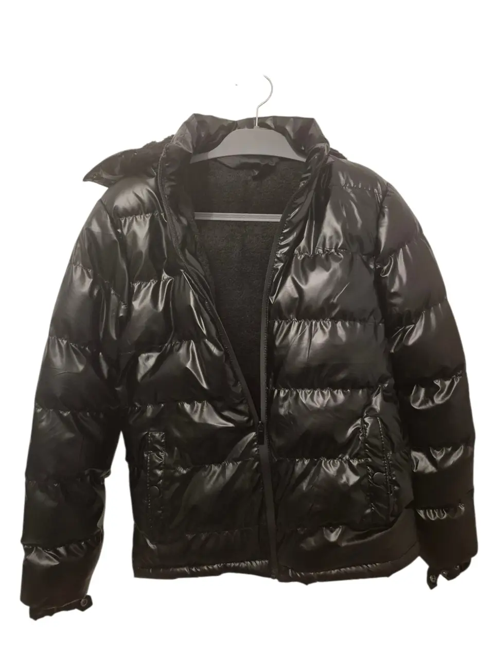 Campera inflable negra con capucha y forro de piel sintética. Ideal para el invierno, abrigada y con un diseño moderno.