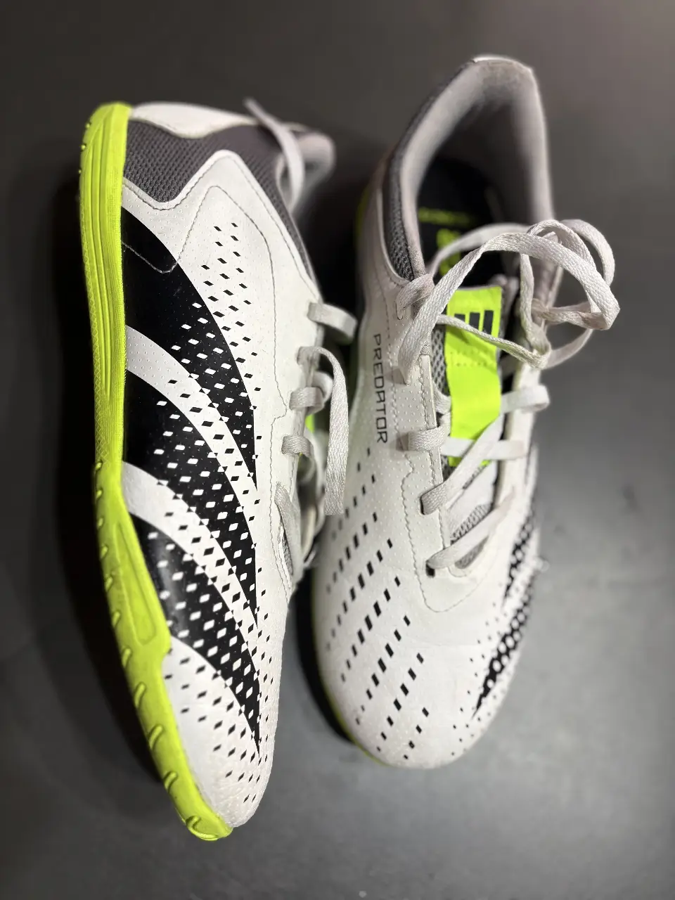 Botines Adidas Predator blancos con detalles en negro y amarillo flúo. Ideales para fútbol indoor.