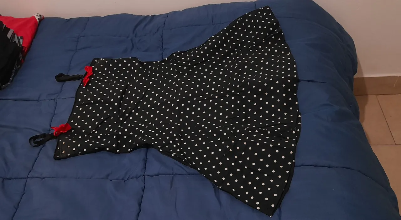 Vestido pin up negro con lunares blancos, escote con tiras y espalda abierta con hebillas, y detalles de moños rojos en los breteles. Se adapta a pecho con busto tranqui y hasta un 95 también. Entallado, hace una figura divina. 